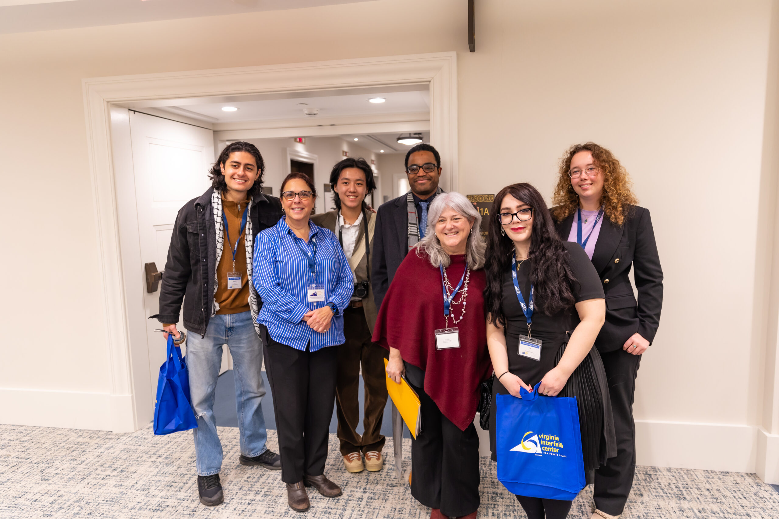 group of people standing together holding VICPP bag
