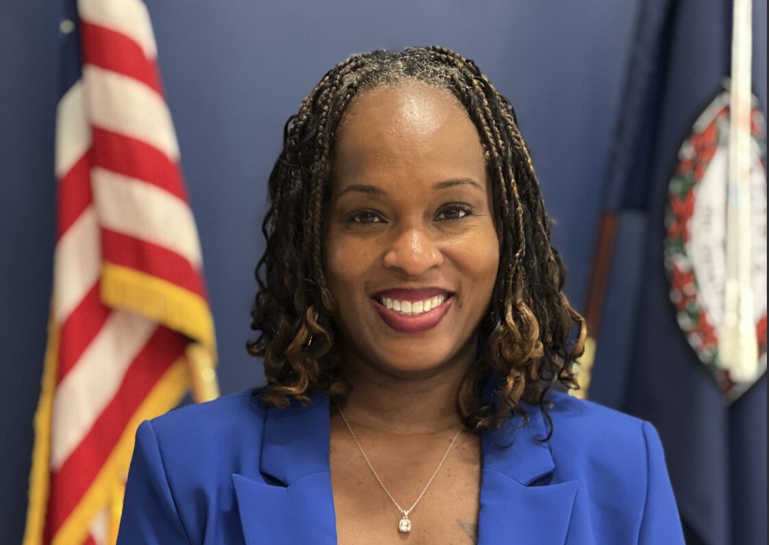 woman with blue blazer and flag behind her