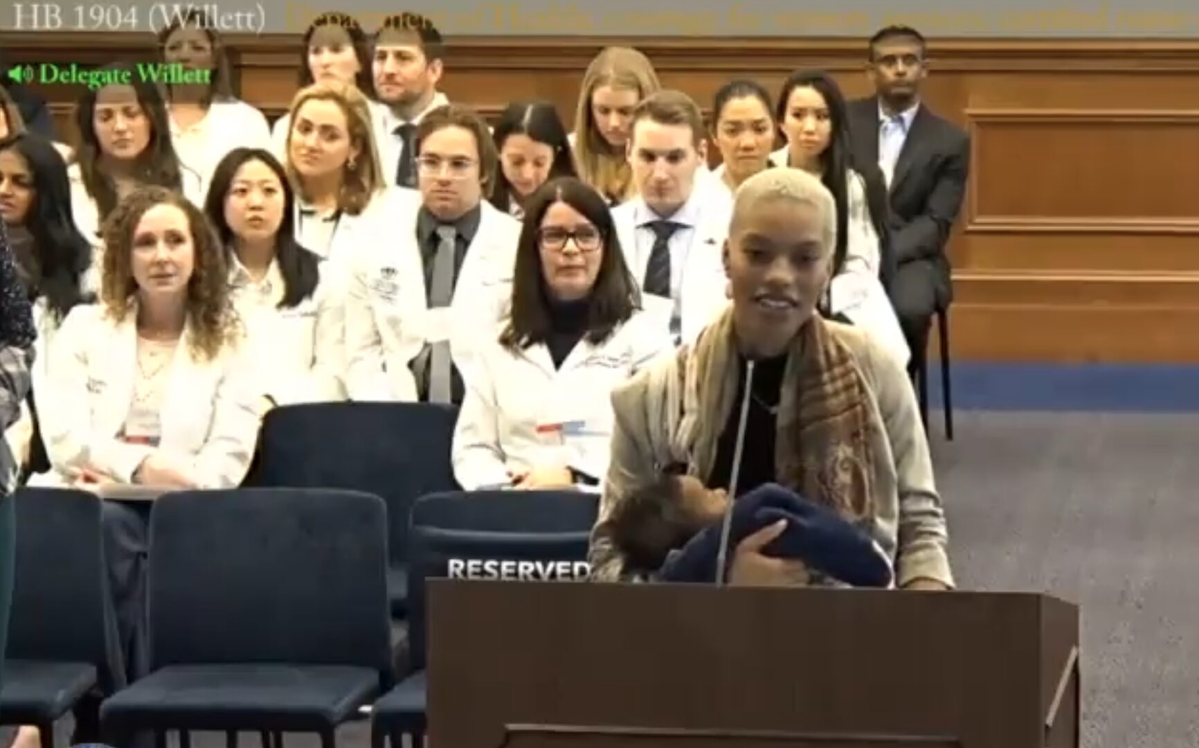 woman holding baby testifies in VA committe hearing