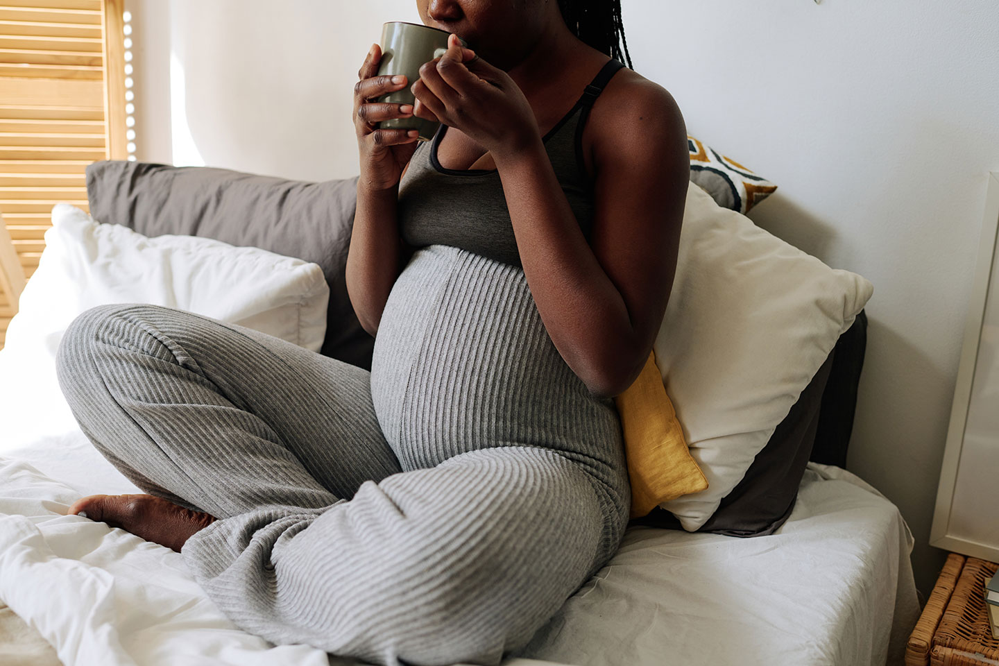 pregnant woman on couch with tea