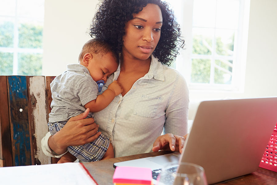 woman working while holding baby