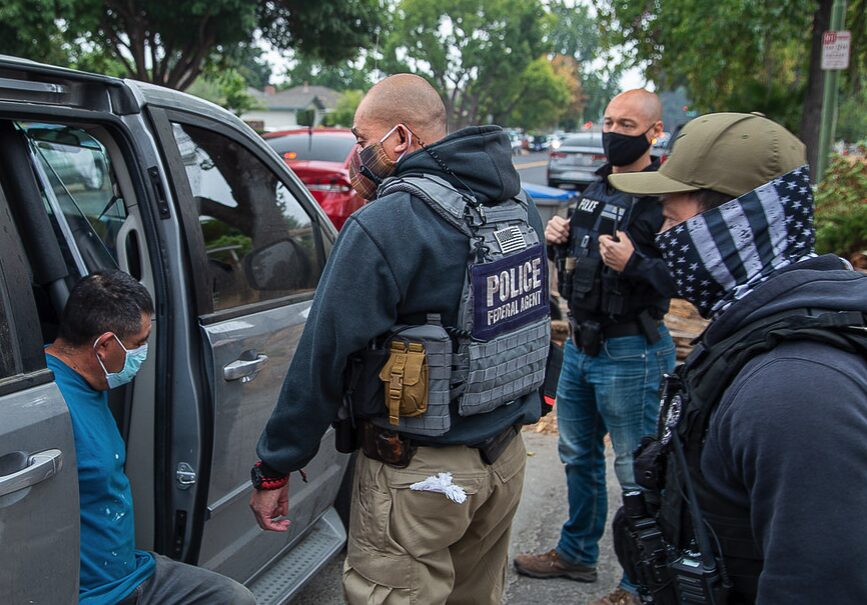 ICE officers arresting man