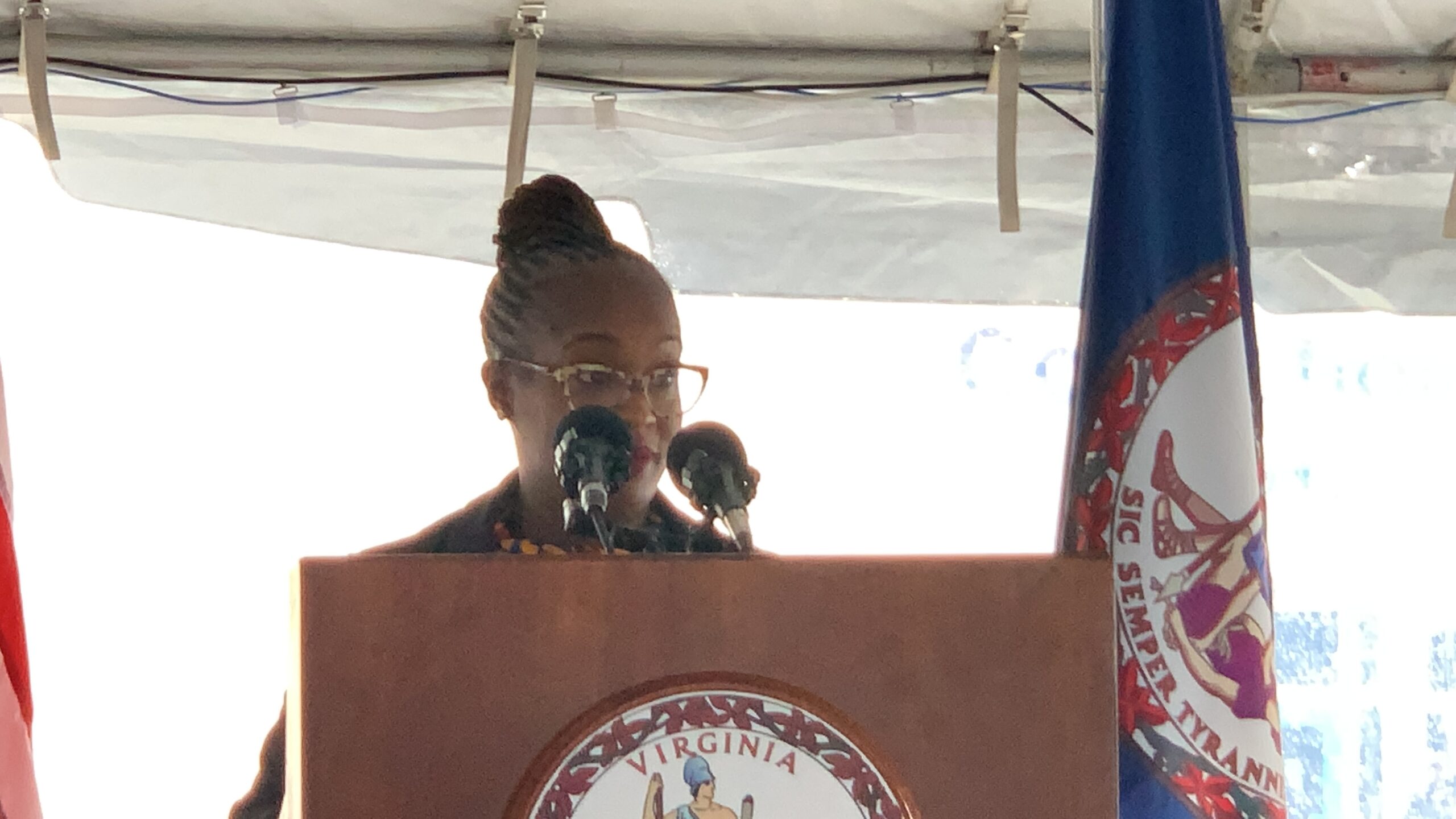 woman speaking at podium with VA flag on rigvht