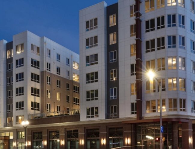 apartment building at dusk with lights on