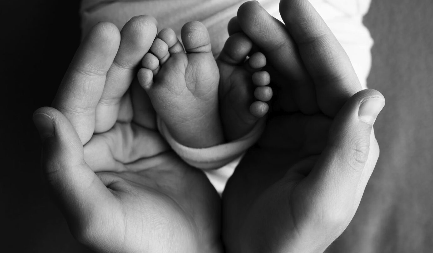 hands hold baby's feet