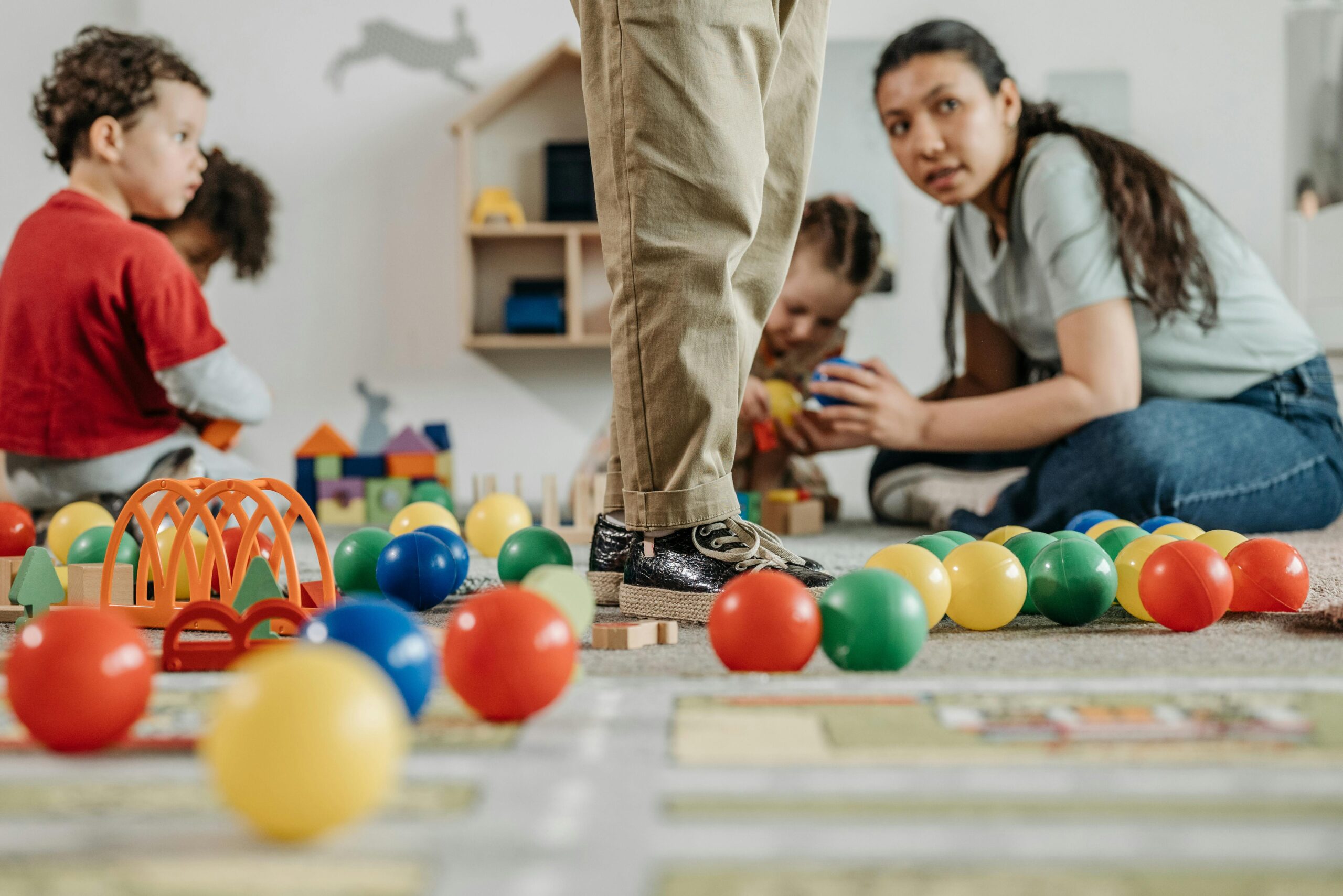 colorful balls and toys and children with adult woman