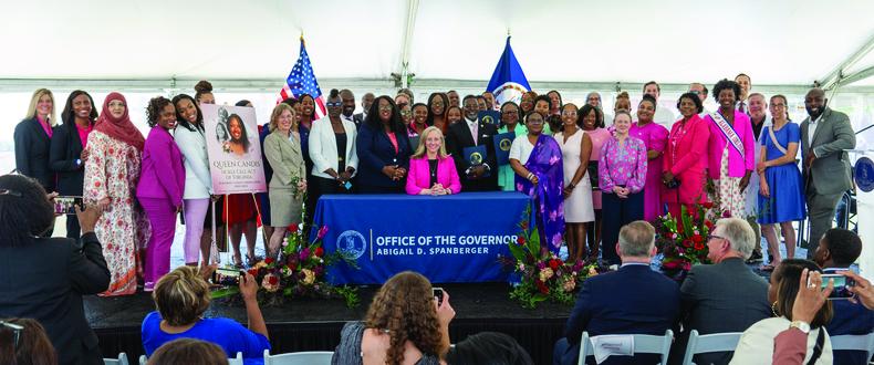 many people standing behind Gov. Spanberger as she signs bill