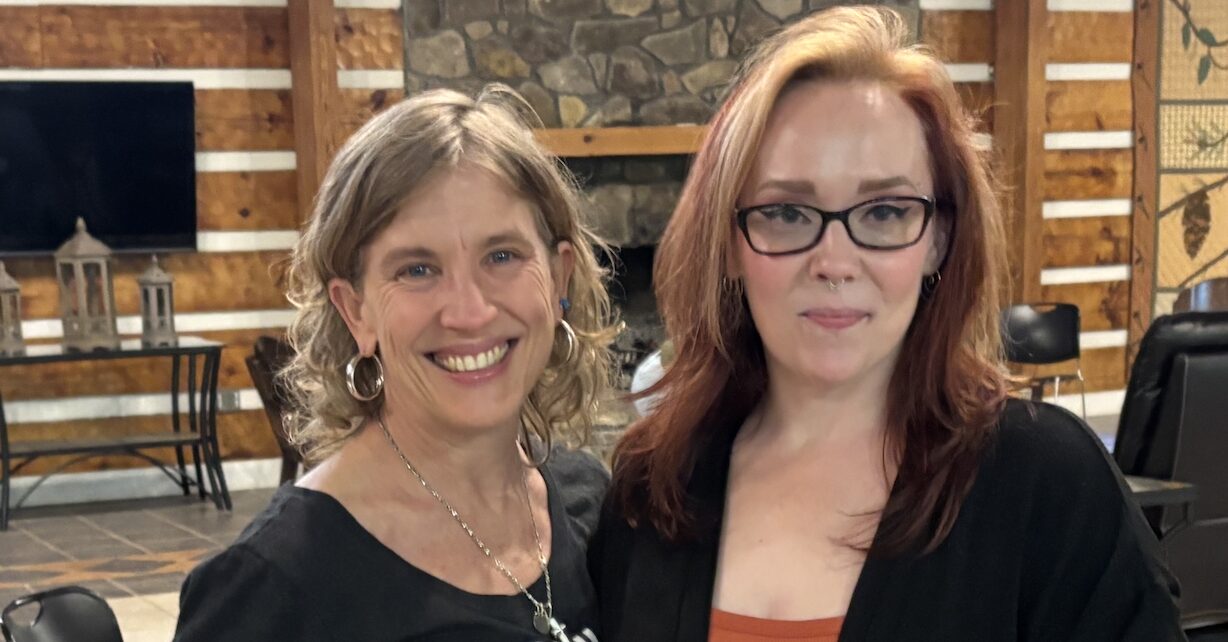 two white women standing together looking at camera